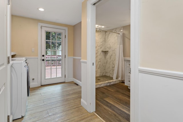 bathroom with a wealth of natural light, wood-type flooring, and independent washer and dryer