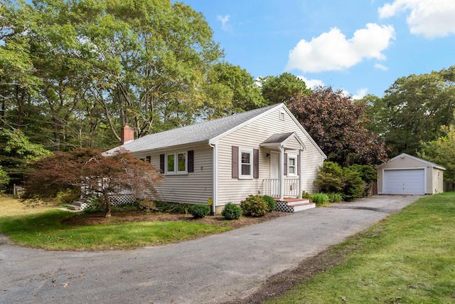 view of front of property featuring a garage, an outbuilding, and a front yard