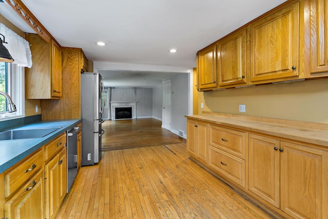 kitchen featuring light hardwood / wood-style floors, sink, butcher block counters, and stainless steel appliances