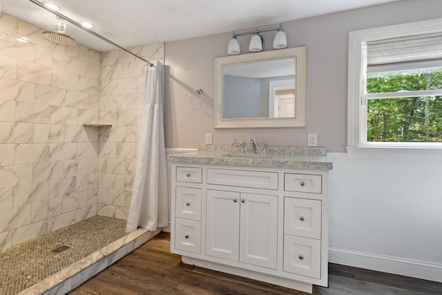 bathroom featuring hardwood / wood-style floors, walk in shower, and vanity