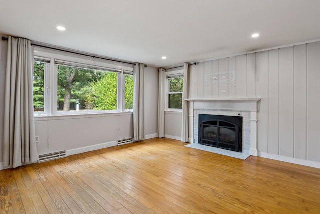 unfurnished living room featuring light wood-type flooring and a fireplace