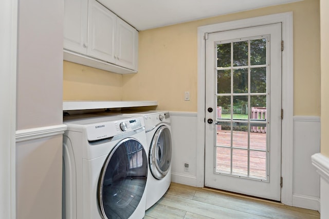 laundry area featuring washer and dryer, cabinets, a healthy amount of sunlight, and light wood-type flooring