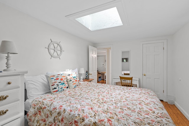 bedroom with light wood-type flooring and a skylight