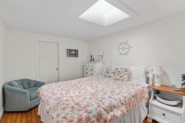 bedroom featuring a skylight and hardwood / wood-style floors