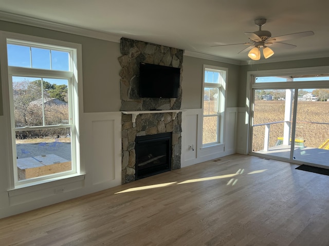 unfurnished living room featuring a fireplace, a healthy amount of sunlight, and ornamental molding