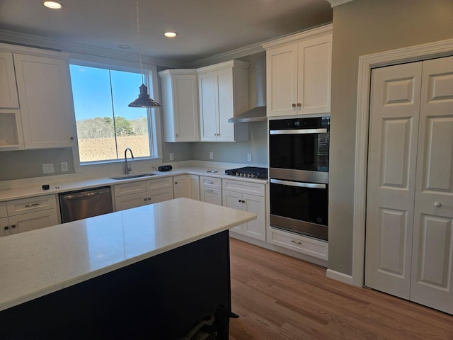 kitchen with pendant lighting, sink, white cabinets, and appliances with stainless steel finishes