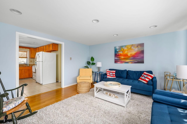 living room featuring recessed lighting, light wood-style flooring, and baseboards