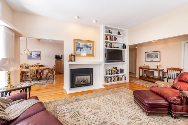 248 Kates Path, Yarmouth Port, MA 02675 - living area with wood finished floors, a fireplace with flush hearth, and built in features