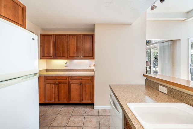 248 Kates Path, Yarmouth Port, MA 02675 - kitchen with white appliances, brown cabinets, light tile patterned floors, and light countertops