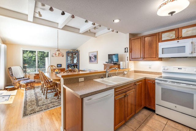 248 Kates Path, Yarmouth Port, MA 02675 - kitchen featuring white appliances, a peninsula, brown cabinetry, decorative light fixtures, and light wood finished floors