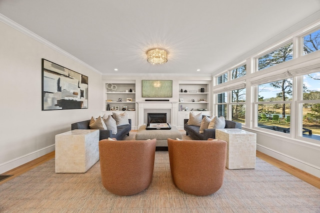 living room with crown molding, built in features, and light hardwood / wood-style flooring