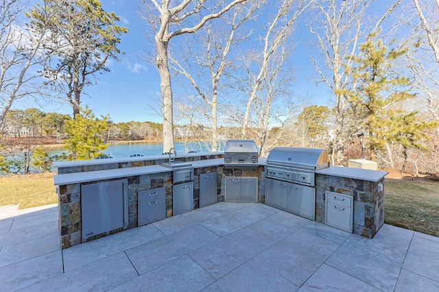 view of patio with a water view, area for grilling, and grilling area