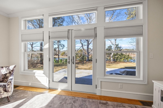 doorway to outside with hardwood / wood-style flooring and ornamental molding