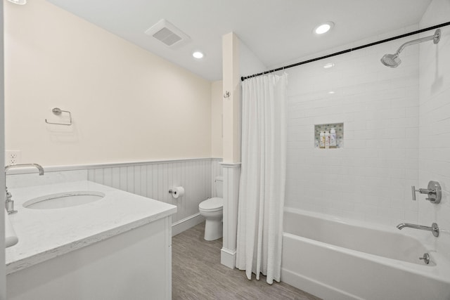 full bathroom featuring vanity, wood-type flooring, shower / bath combination with curtain, and toilet