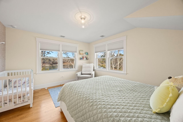 bedroom featuring vaulted ceiling and light hardwood / wood-style floors