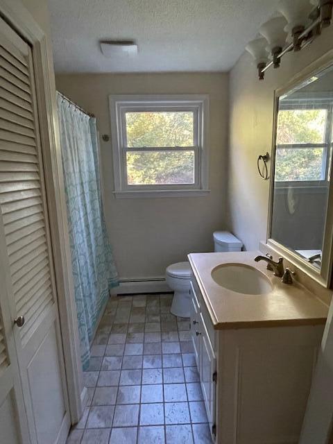 103 Braeside Rd, West Falmouth, MA 02540 - full bathroom featuring vanity, toilet, a textured ceiling, a baseboard heating unit, and a closet