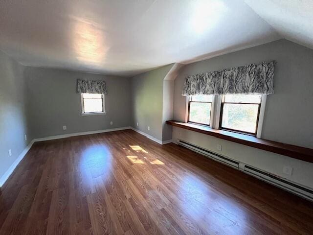 spare room featuring dark wood-style floors, a baseboard radiator, lofted ceiling, and baseboards