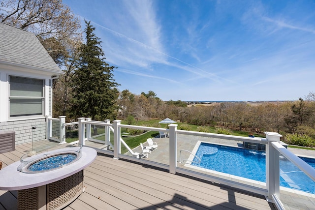 outdoor pool with a fire pit and a deck
