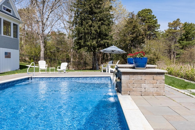 view of pool featuring fence and view of wooded area