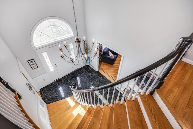 foyer with a high ceiling, stairway, and a chandelier