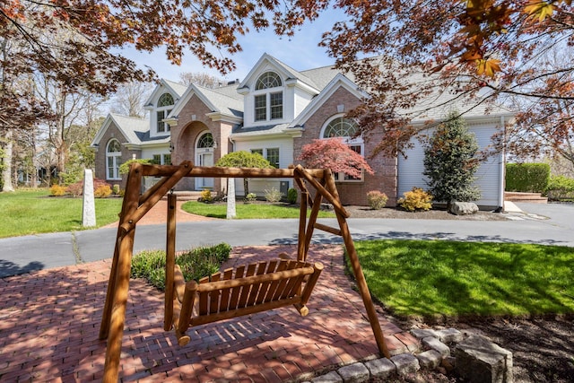 traditional home with a front lawn, driveway, and brick siding