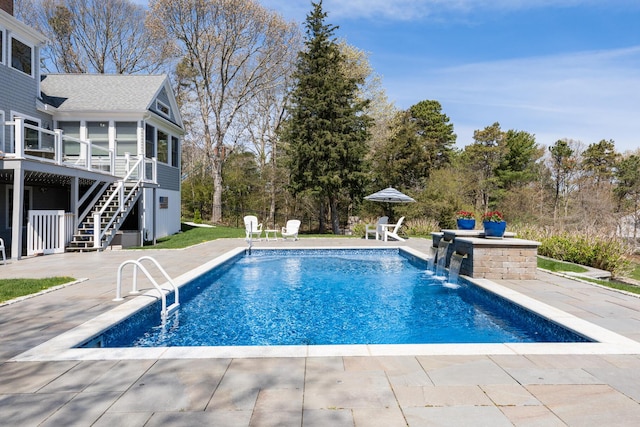 view of pool featuring stairs, a deck, a patio, fence, and view of scattered trees