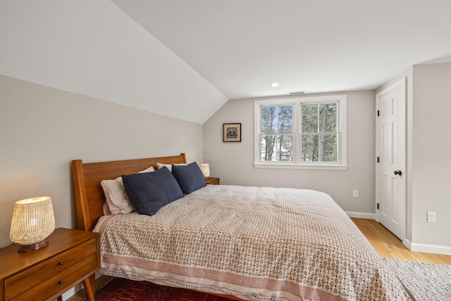 bedroom with lofted ceiling and hardwood / wood-style floors