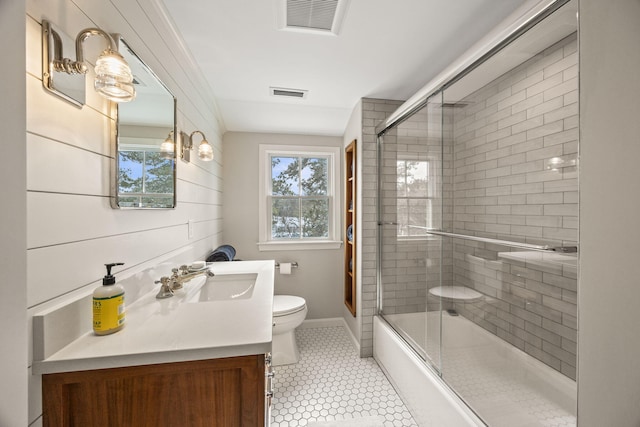 full bathroom with enclosed tub / shower combo, vanity, tile patterned flooring, and toilet