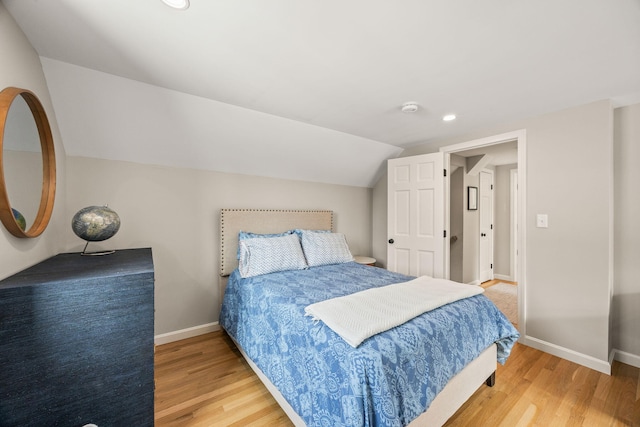 bedroom with vaulted ceiling and wood-type flooring