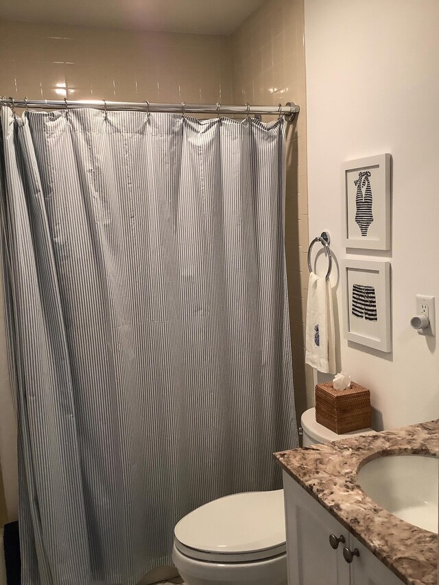 bathroom featuring vanity, toilet, and curtained shower