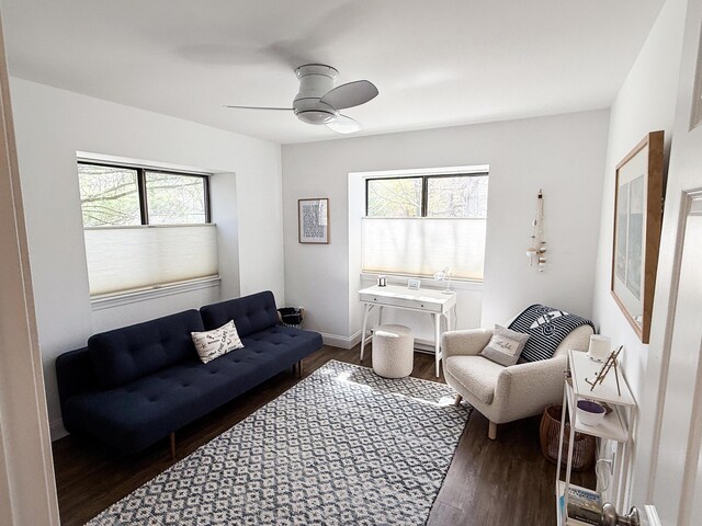 living room featuring baseboards, a ceiling fan, and wood finished floors