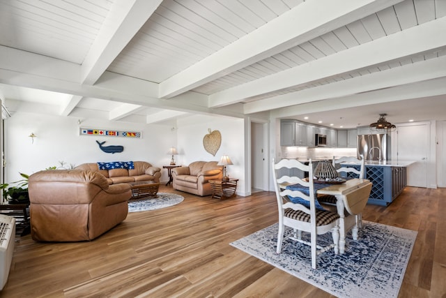 living room featuring beam ceiling and light wood-type flooring