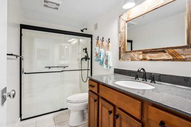 bathroom with vanity, a shower with shower door, tile patterned floors, and toilet