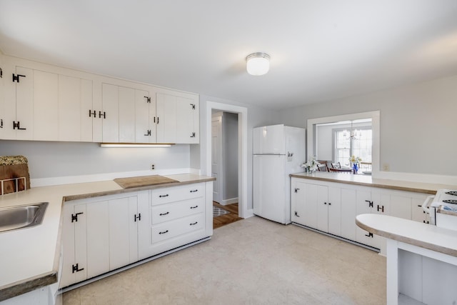 14 Trinity Cv, West Harwich, MA 02671 - kitchen featuring freestanding refrigerator, white cabinets, light countertops, and a chandelier