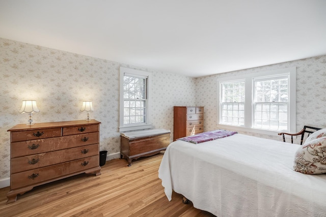 bedroom featuring wallpapered walls and light wood finished floors