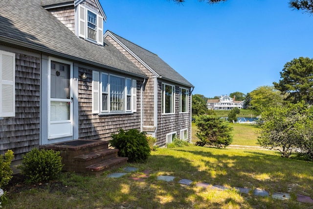 14 Trinity Cv, West Harwich, MA 02671 - view of home's exterior with a yard, a shingled roof, and a water view