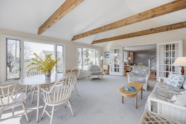 carpeted living area featuring french doors, vaulted ceiling with beams, and stairway