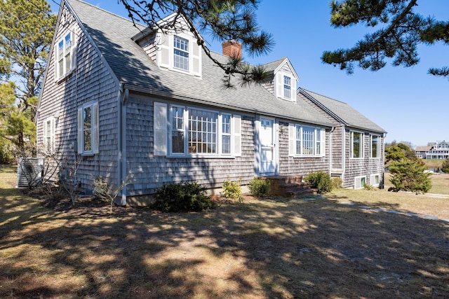 view of front of house featuring roof with shingles and a chimney