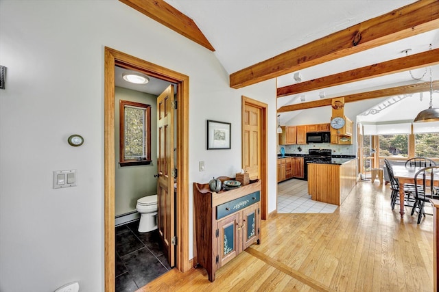 3 Amber Way, Truro, MA 02666 - kitchen with black appliances, dark countertops, a baseboard radiator, brown cabinetry, and light wood finished floors