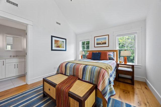 29 Point St, Provincetown, MA 02657 - bedroom with light wood finished floors, a sink, ensuite bathroom, baseboards, and high vaulted ceiling
