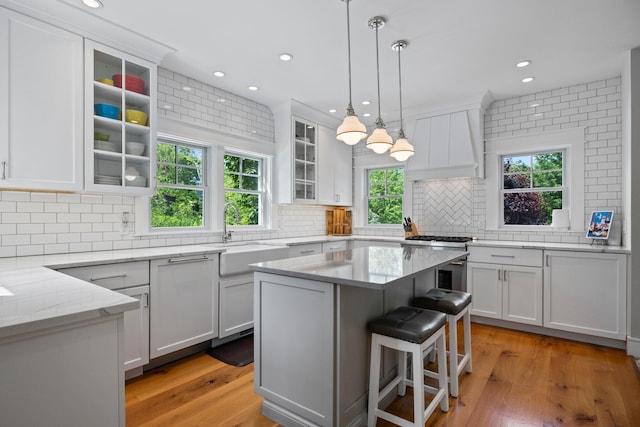 29 Point St, Provincetown, MA 02657 - kitchen with a sink, custom exhaust hood, white cabinets, backsplash, and stainless steel gas range