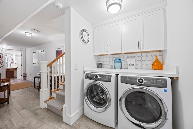 29 Point St, Provincetown, MA 02657 - laundry room featuring washer and clothes dryer, light wood finished floors, baseboards, and cabinet space