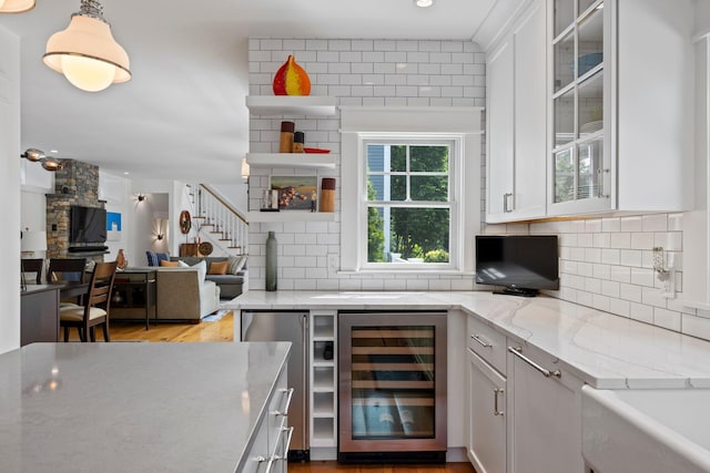 29 Point St, Provincetown, MA 02657 - kitchen featuring beverage cooler, backsplash, light stone counters, white cabinets, and recessed lighting