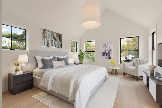 bedroom featuring light hardwood / wood-style floors and a towering ceiling