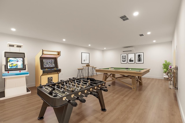 rec room with wood-type flooring and a wall mounted air conditioner