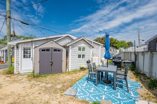 241 Old Wharf Rd Unit 90, Dennis Port, MA 02639 - rear view of property featuring a storage unit, a patio, and an outdoor structure