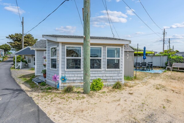 241 Old Wharf Rd Unit 90, Dennis Port, MA 02639 - view of side of home featuring roof with shingles and fence