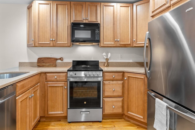 kitchen with sink, light hardwood / wood-style flooring, and stainless steel appliances