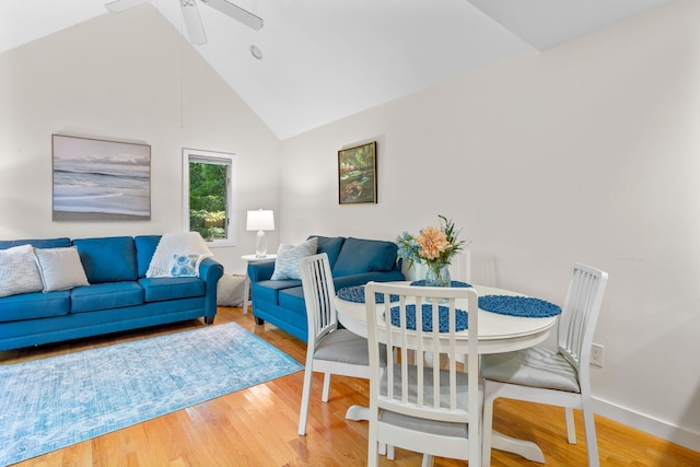 dining area with wood-type flooring, high vaulted ceiling, and ceiling fan