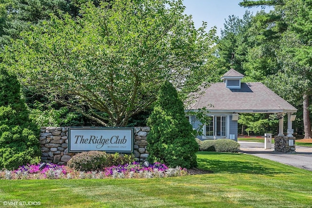 community / neighborhood sign featuring a lawn